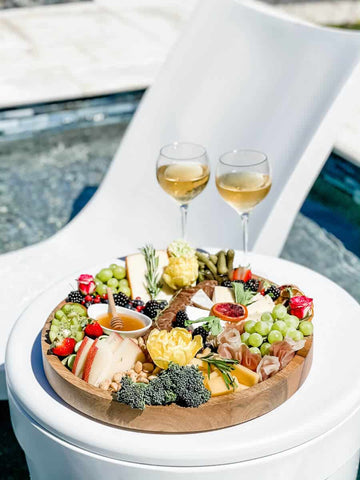 Charcuterie board and wine on in-pool side table