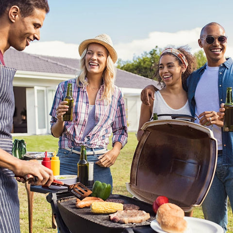 Two couples around grill having backyard barbecue
