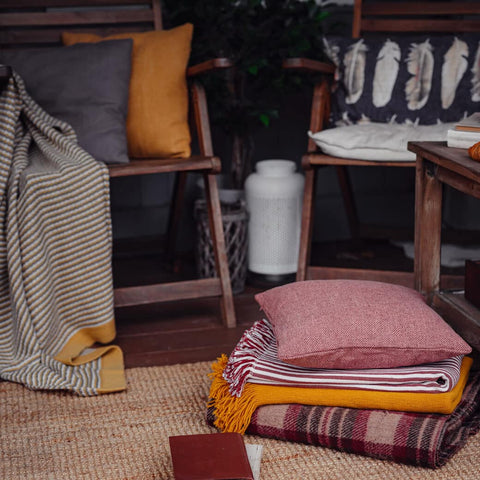 Blankets and throw pillows on wood chairs and floor