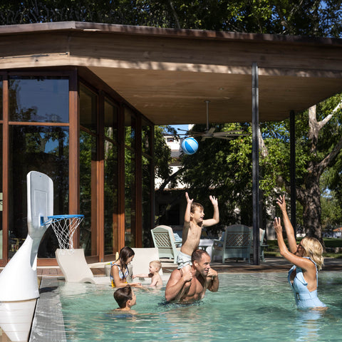 Family playing in the pool with Hoopstr in-pool basketball hoop by Ledge