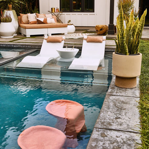 Ledge Loungers barstools, chaises, and side table in pool