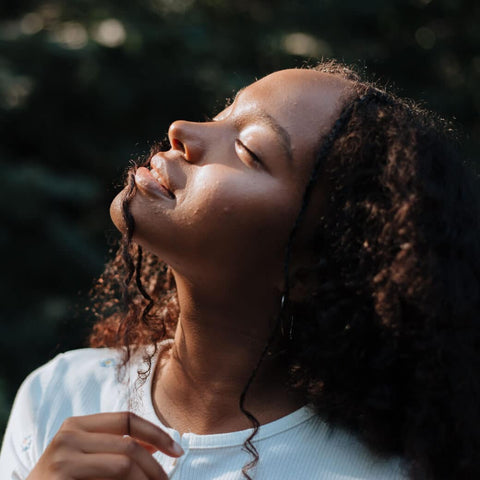 Women looking upwards with closed eyes and sunlight on her face