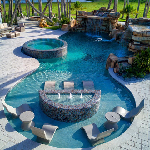 Large pool with water features and Ledge Lounger products in the water