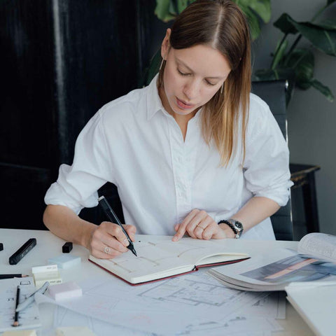 woman drawing in a journal in business attire