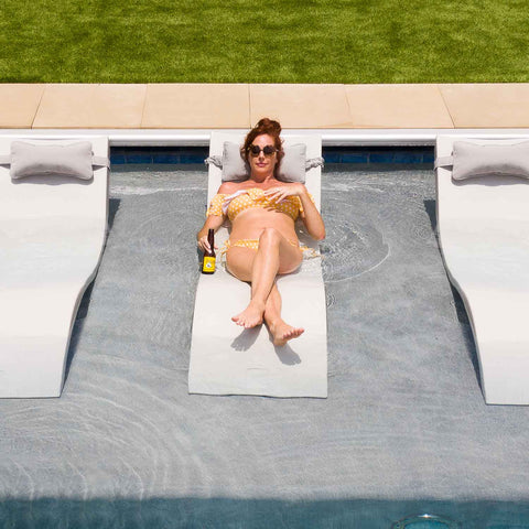 woman in a yellow bikini laying on an in-pool chaise