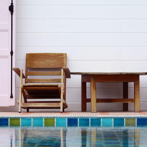 Wood chair and small table next to pool