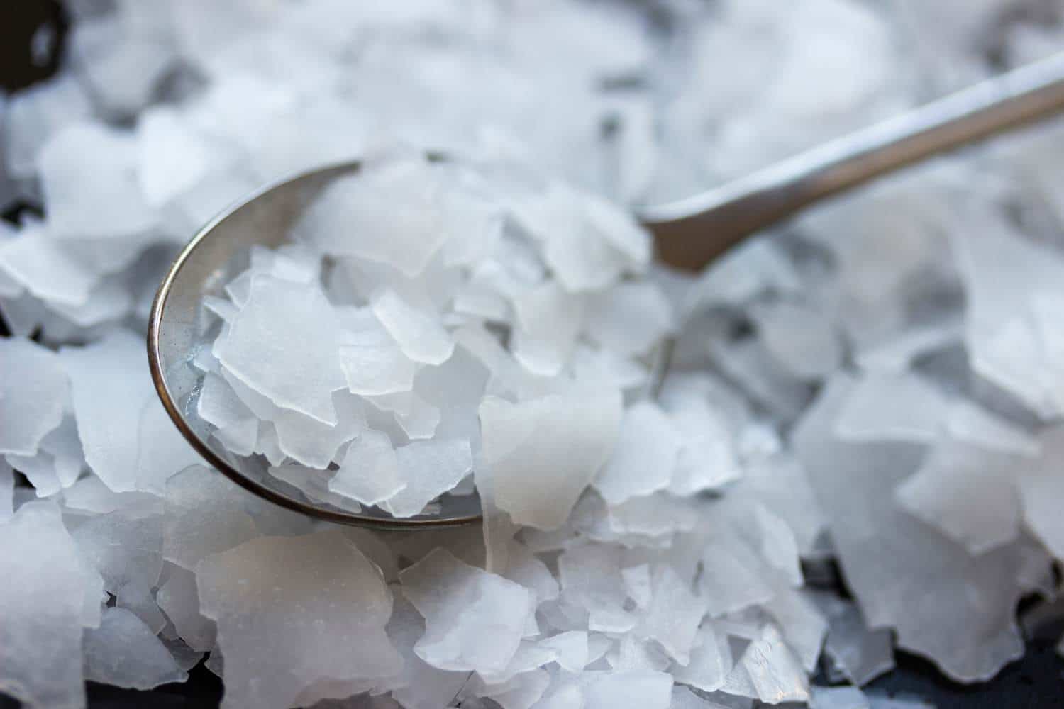 A spoonful of magnesium on a black plate.