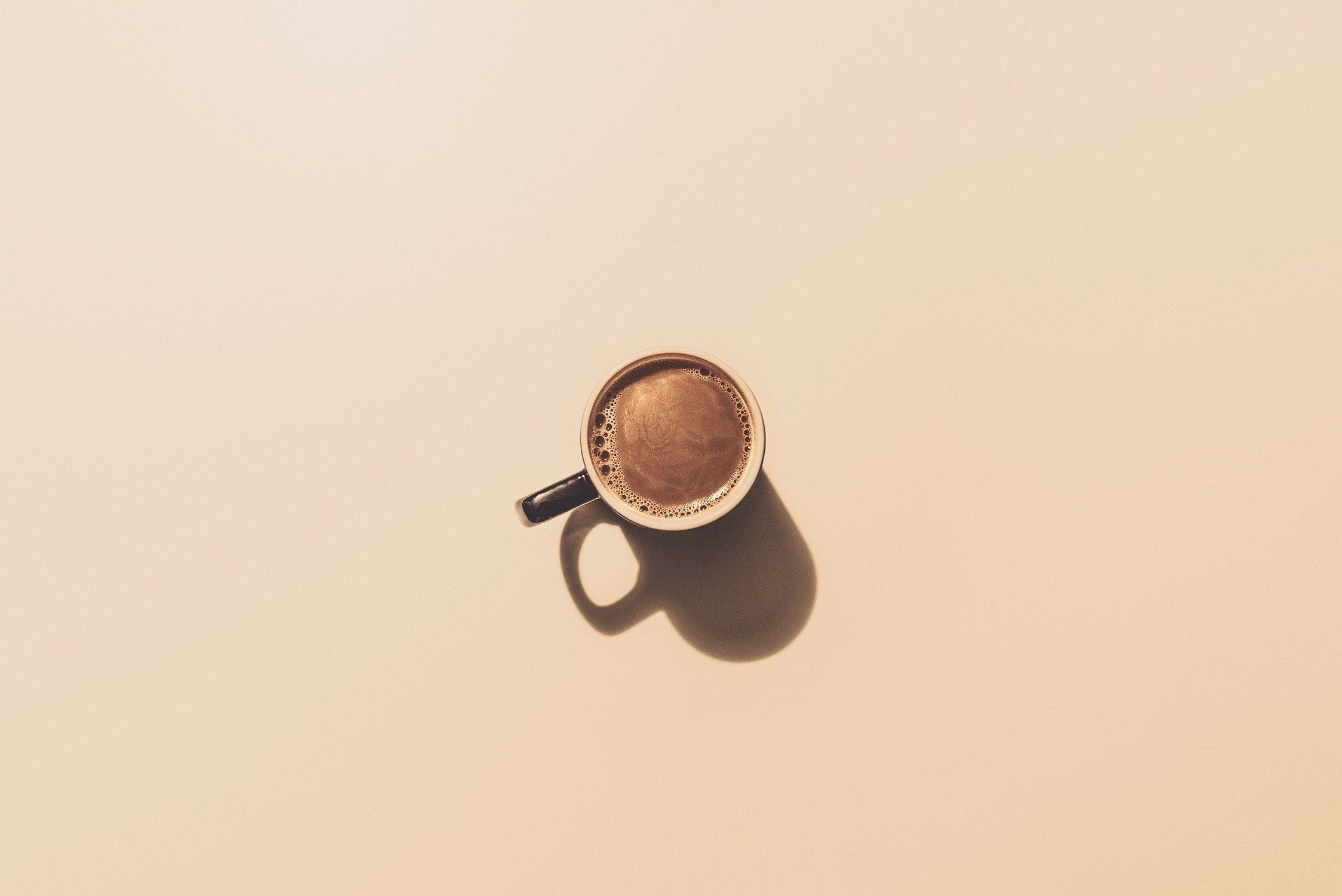 warm cup of coffee on a beige counter