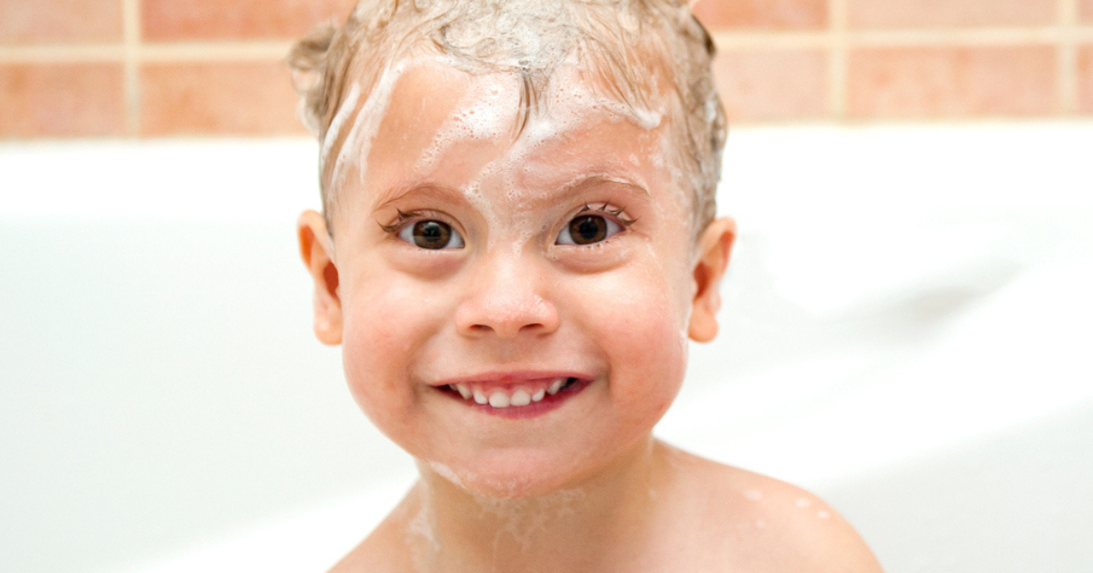 A little boy smiling in the bath after having his head treated with Nit-Zapping Clenz Shampoo, a natural lice shampoo, by Hair Fairies.