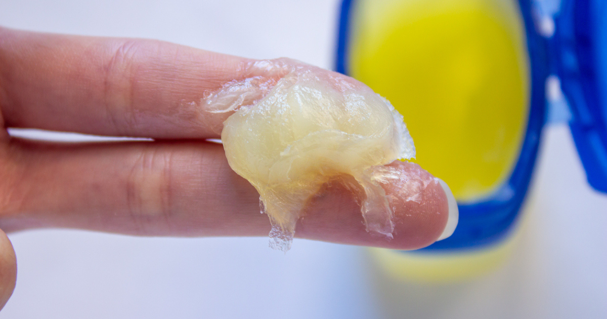 Two fingers with a scoop of petroleum jelly.