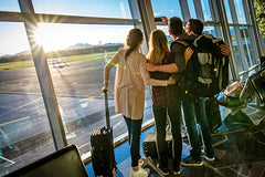 Family in an airport looking out the window towards the runway