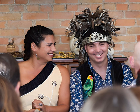 Wedding photo of co-founders of Alliance of Native Seedkeepers, smiling in front of guest in traditional regalia.
