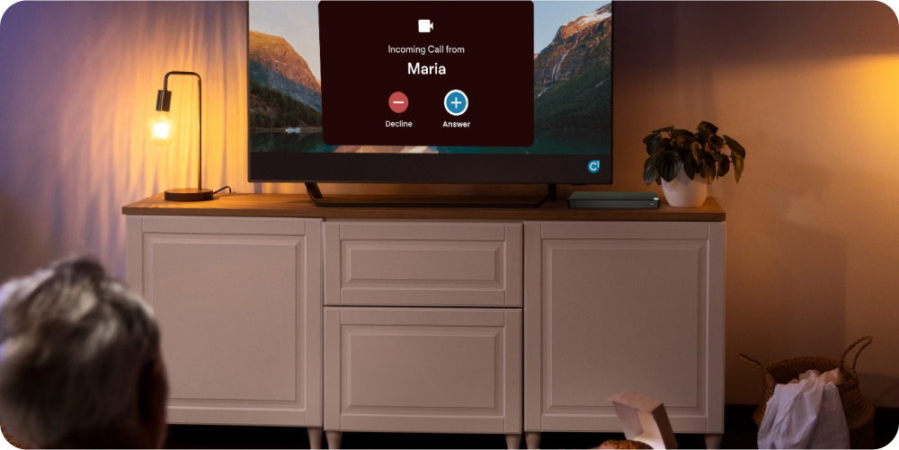 elderly man watching tv with a video call incoming on his tv