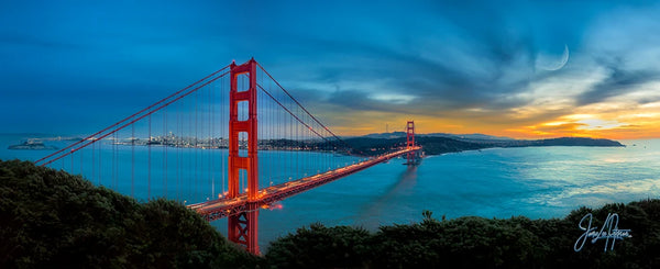Panoramic view of the Golden Gate Bridge at sunset with vibrant skies, reflecting the iconic structure's elegance over the San Francisco Bay.