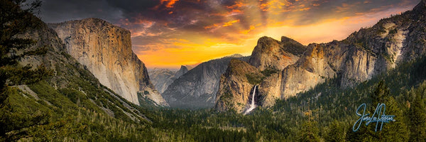 A breathtaking panorama capturing the sun's first rays illuminating Yosemite's cliffs and waterfalls, set against a vivid sky, embodying the awe-inspiring tranquility of nature.
