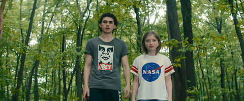 Leave the World Behind Archie and Rosie outside in the woods after the sound wearing tshirts Obey and NASA