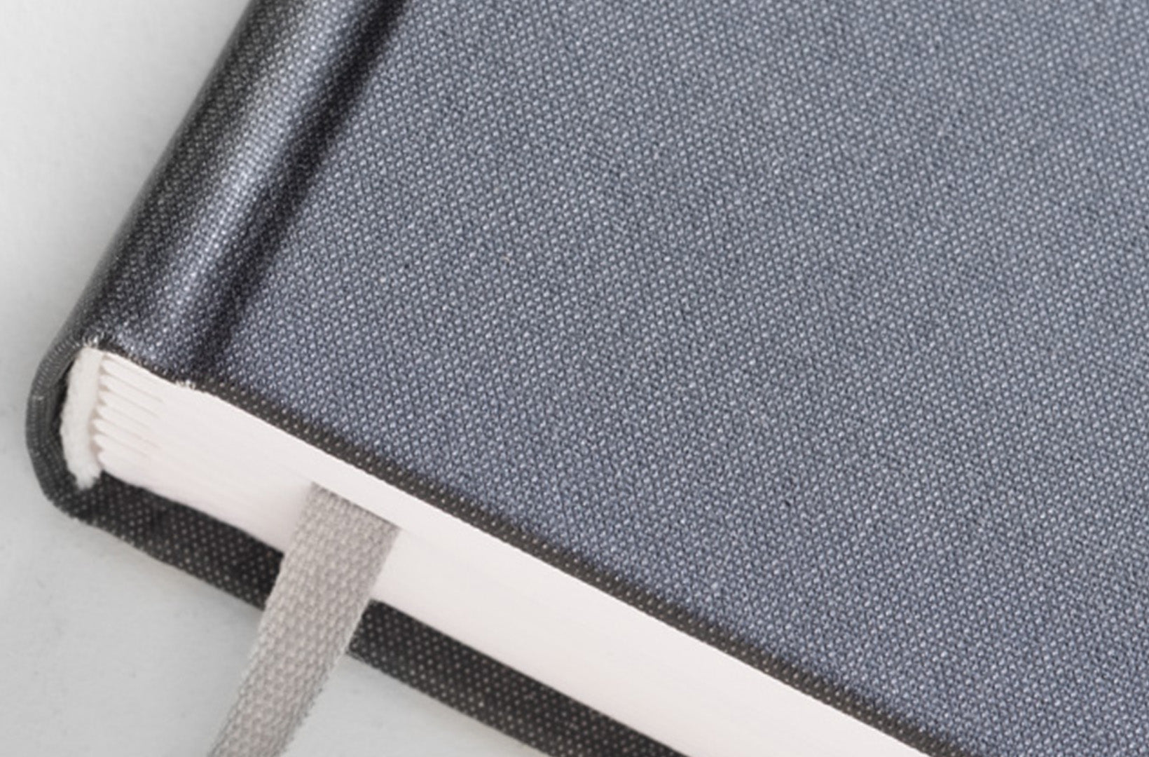 A detail shot of the hardcover Daily Planner shows the lover left corner and grosgrain ribbon.