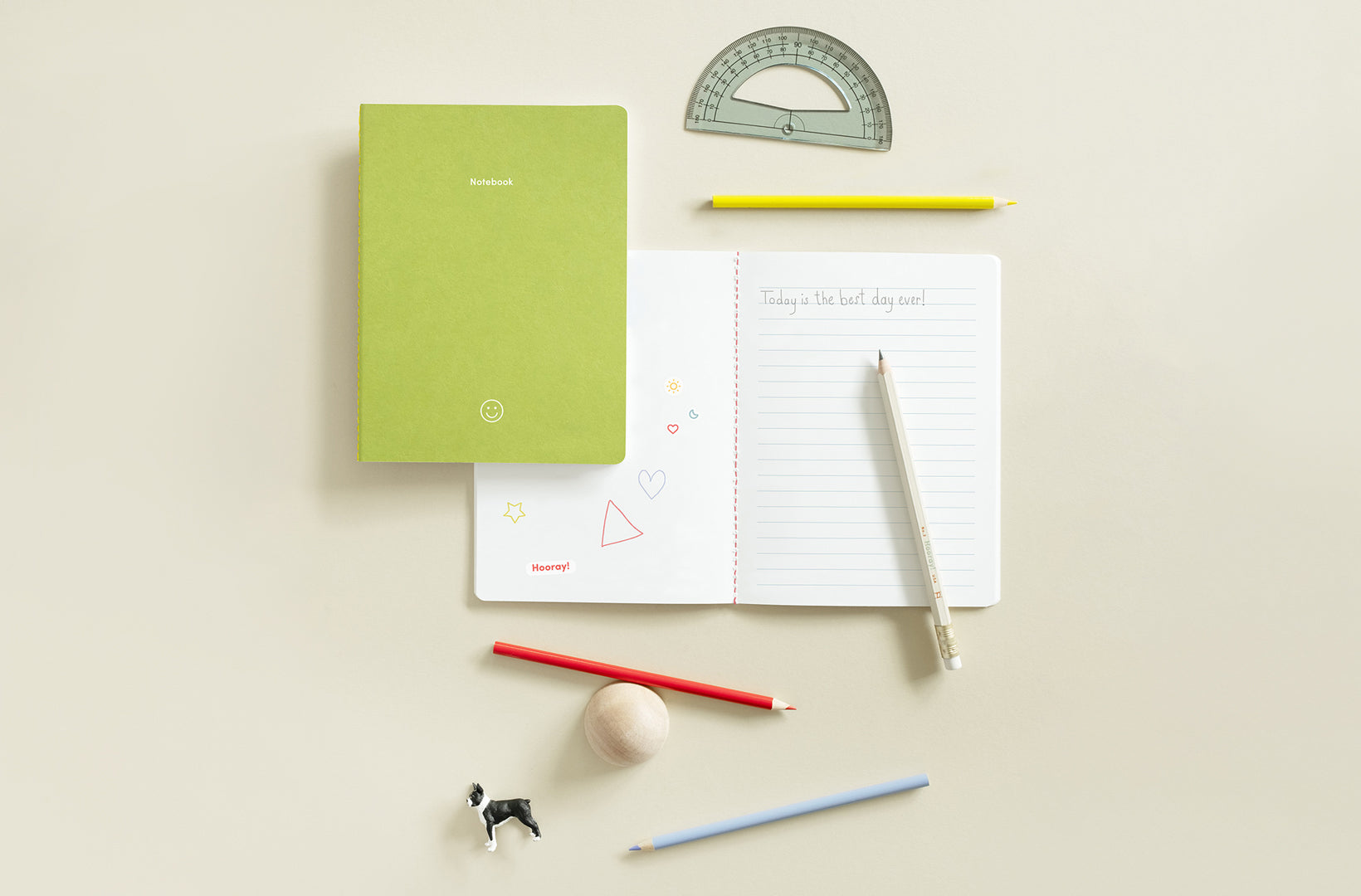 The Clover and Mist Notebook Set from the Appointed Kids collection sit against a light beige background. The mist notebook is open and laying flat with some doodles drawn. Colorful pencils, a protractor, and small animal toys lay aside.