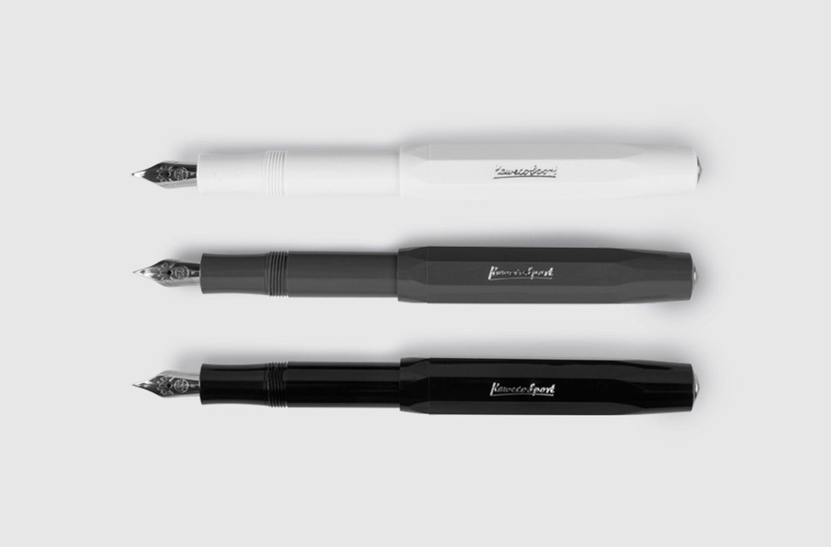 Three skyline sport fountain pens in white, gray, and black sit uncapped against a light gray background