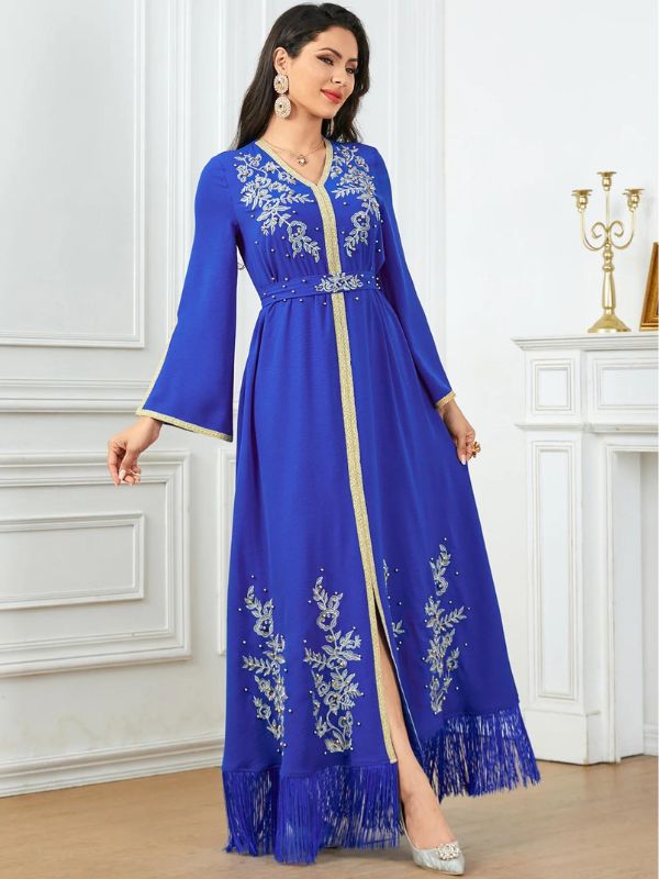 Femme élégante qui est porte un caftan bleu royal dans un intérieur de prestige