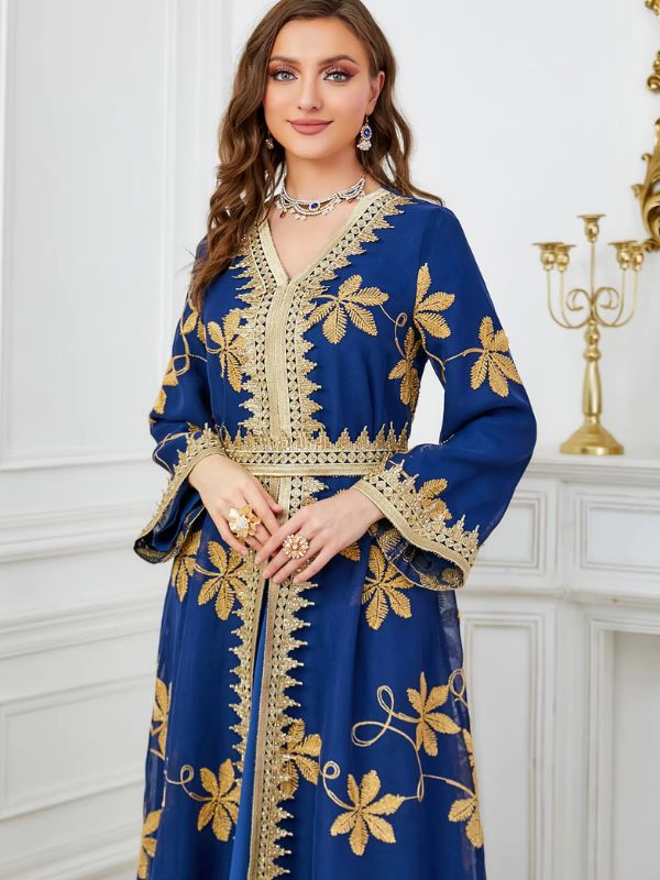 Une femme sourit à la caméra et porte un caftan de couleur bleu