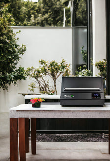 Turbo E, the versatile outdoor electric grill, in a luxurious villa backyard for day grilling.