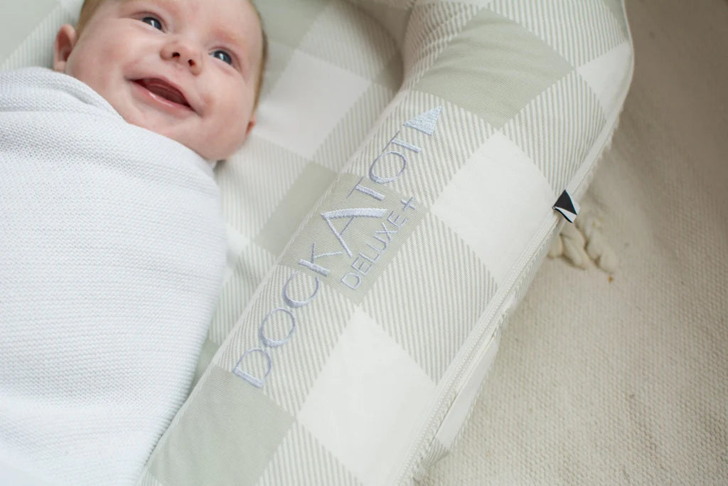 Smiling baby in DockAtot Deluxe+