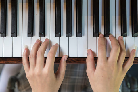 Hands on piano - top view