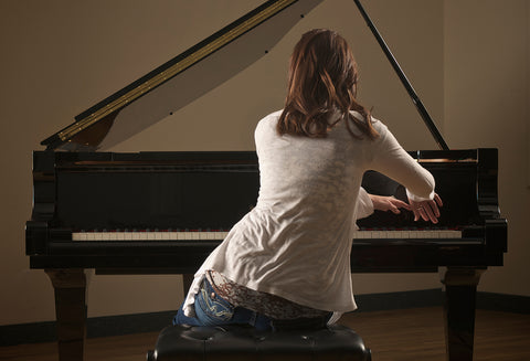 woman tiling body toward right playing piano