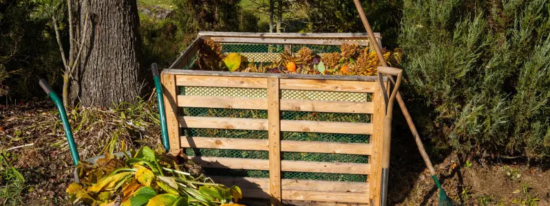 A compost bin in a backyard.