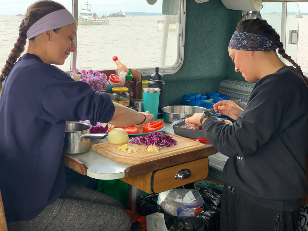 Ashley and Nora prepare a sockeye lunch while anchored up, waiting for the fishery-opening announcement. 