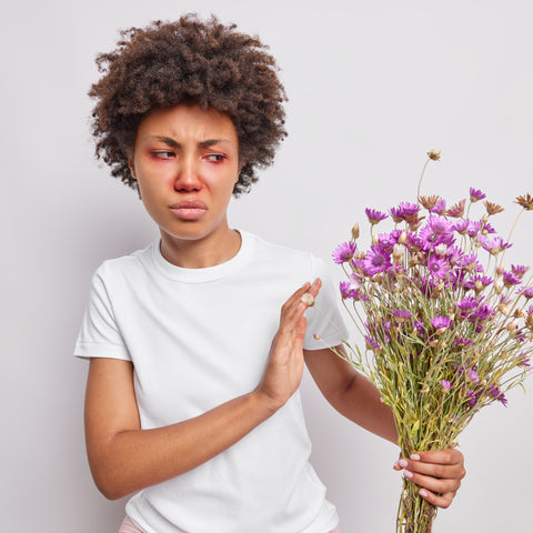 woman with allergies holding flowers and looking unhappy.  Celt Naturals Immuno-care natural Allergy Relief, allergies relief, natural remedies for allergies
