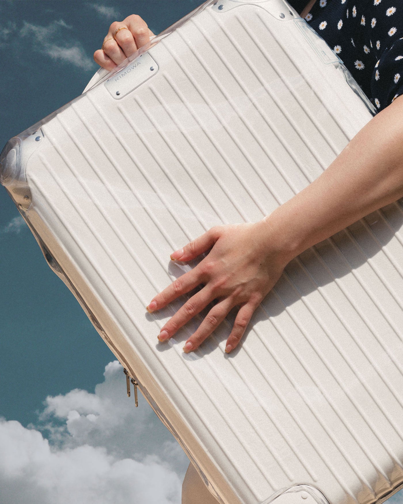 Girl holding Rimowa hybrid check in M luggage in white