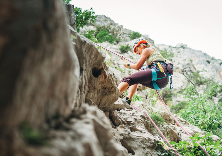 Active climber woman in protective helmet