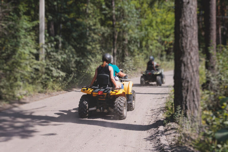 Group of riders riding ATV vehicle crossing