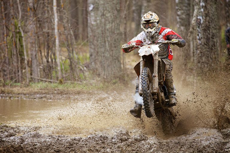 Motocross racer on wet and muddy terrain in Finland