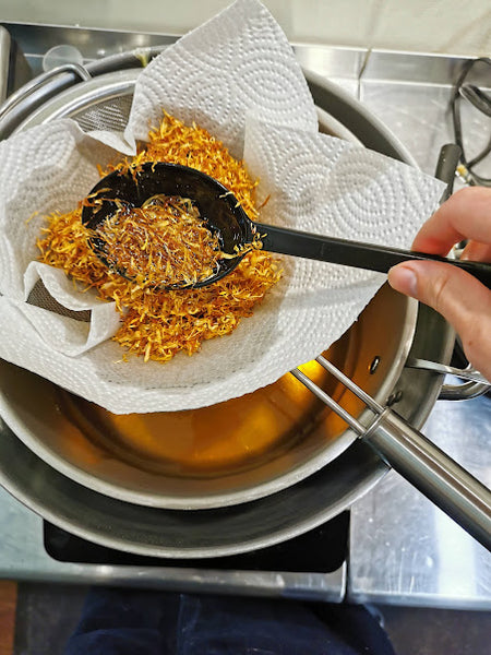 Dried, organic calendula petals after infusing in oil