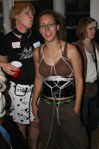 A lady with a bondage harness with a group of people from the bondage community.