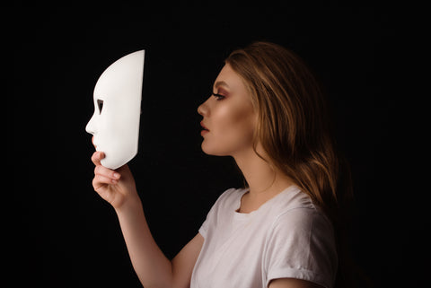 A woman hiding behind a mask.