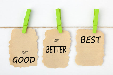 Signs hanging from clothes pins that say good, better, best.