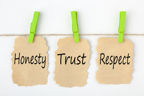 Signs hanging from clothes pins with the words honesty, trust, respect.