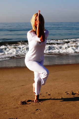 Woman doing Yoga -- Eagle Pose on the beach.