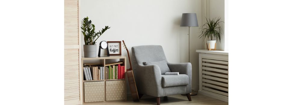 reading chair in the corner of a room with small shelving unit to store books