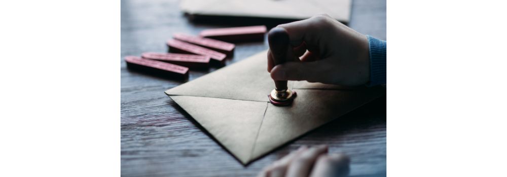 letter in an envelope being sealed with wax and stamped