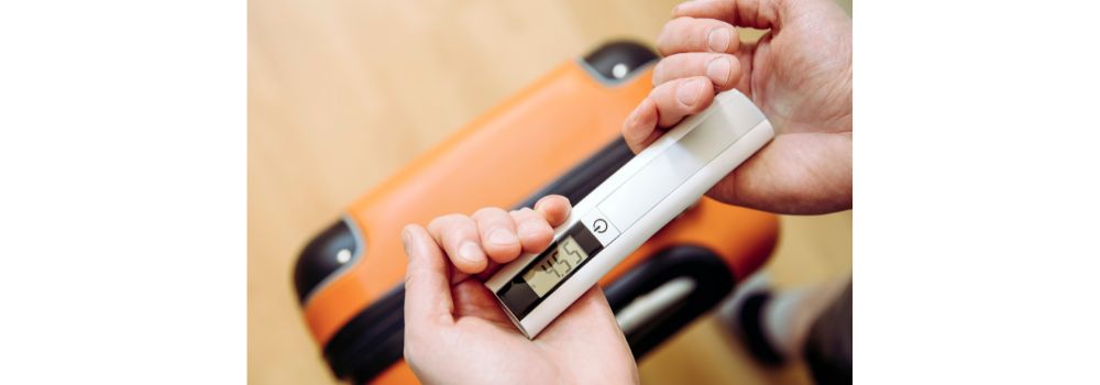 digital luggage scales being used to check the weight of a suitcase