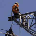 Homme travaillant en hauteur sur une tour électrique