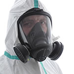 Homme en combinaison de matières dangereuses portant un masque à gaz complet