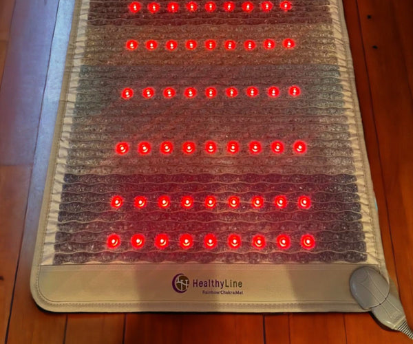 red light therapy mat lit up on wood floor