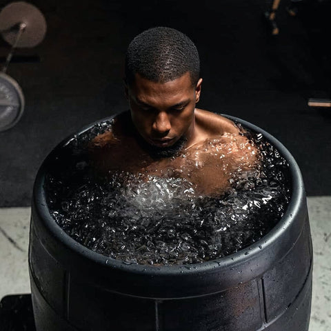 athletic man submerges into ice bath to enhance is athletic recovery