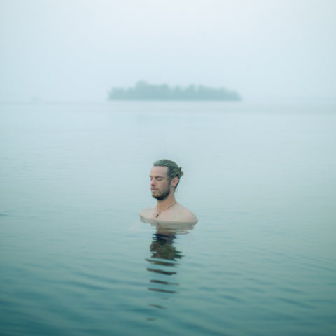 man engaged in cold therapy in a lake